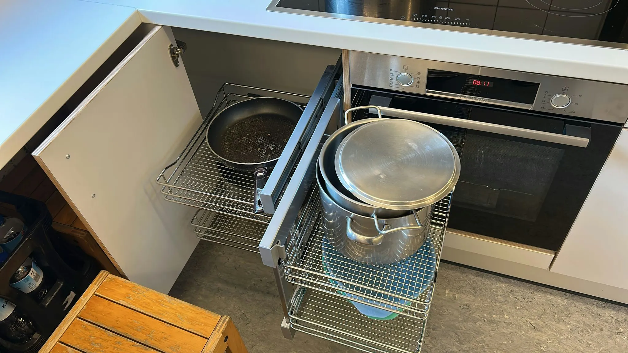 Ein Auszugsregal mit Töpfen neben dem Backofen